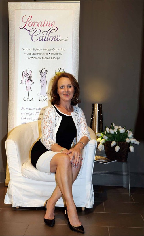 Loraine sitting elegantly in front of her trade banner
